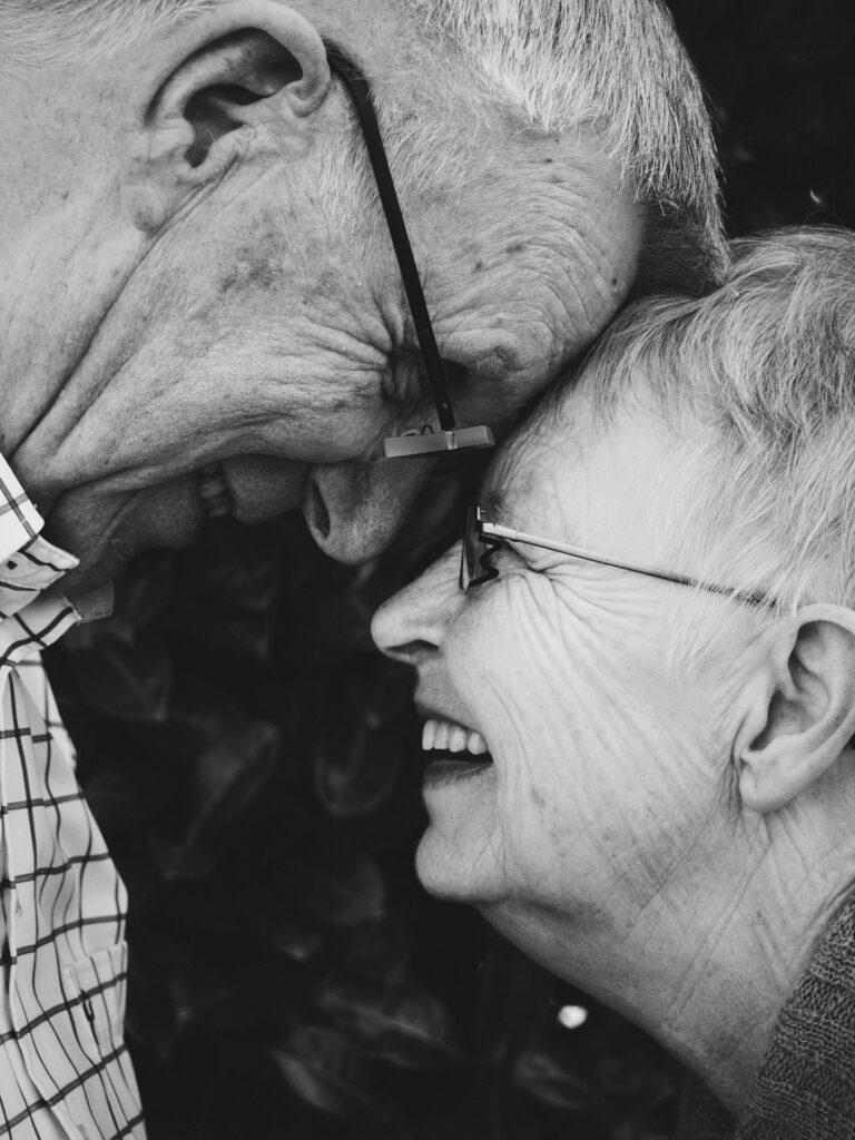 Older couple with forehead to forehead and smiling at each other